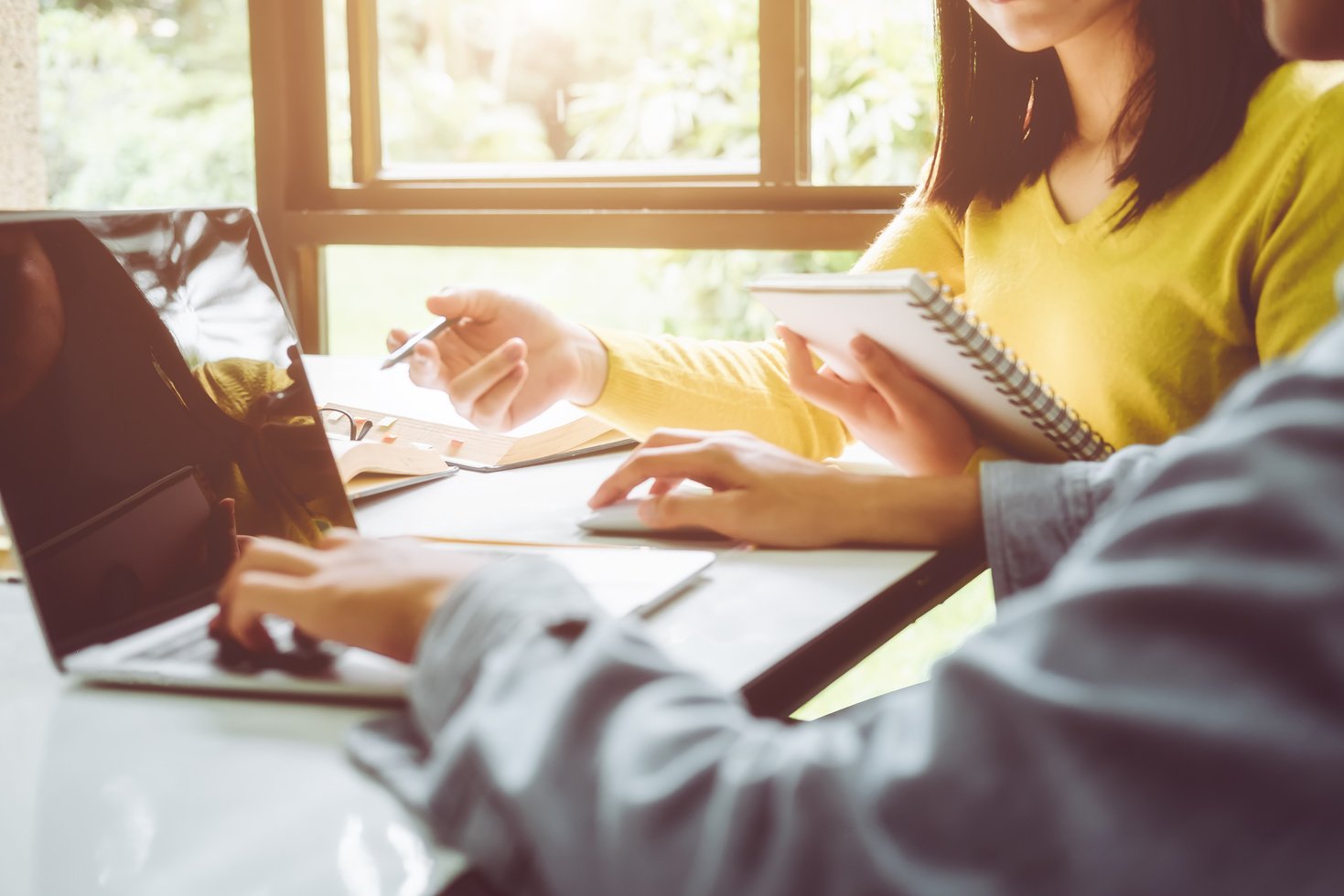Students Using Laptop While Doing Research in Library
